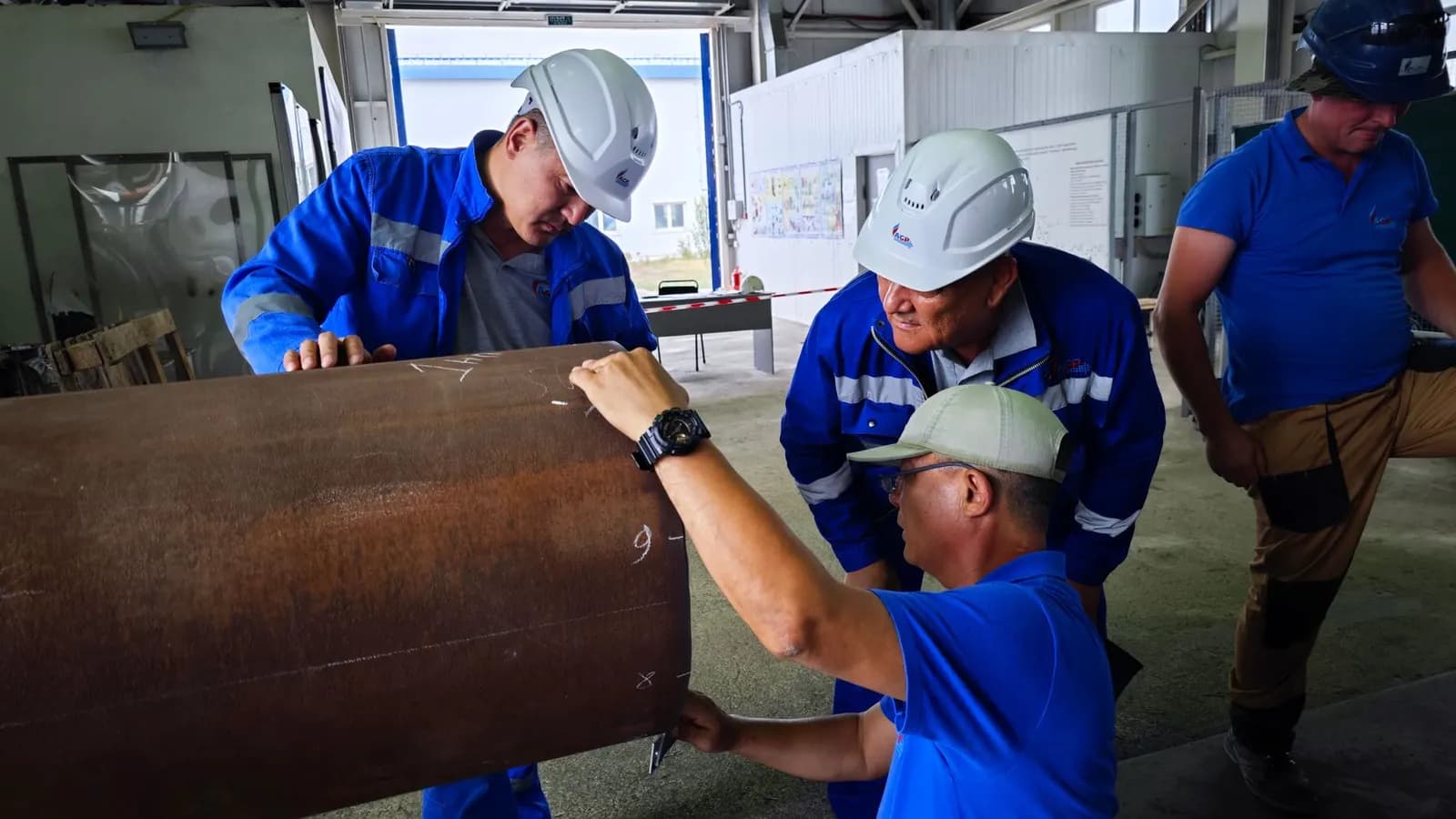 Engineers handling a large pipe on a commercial site
