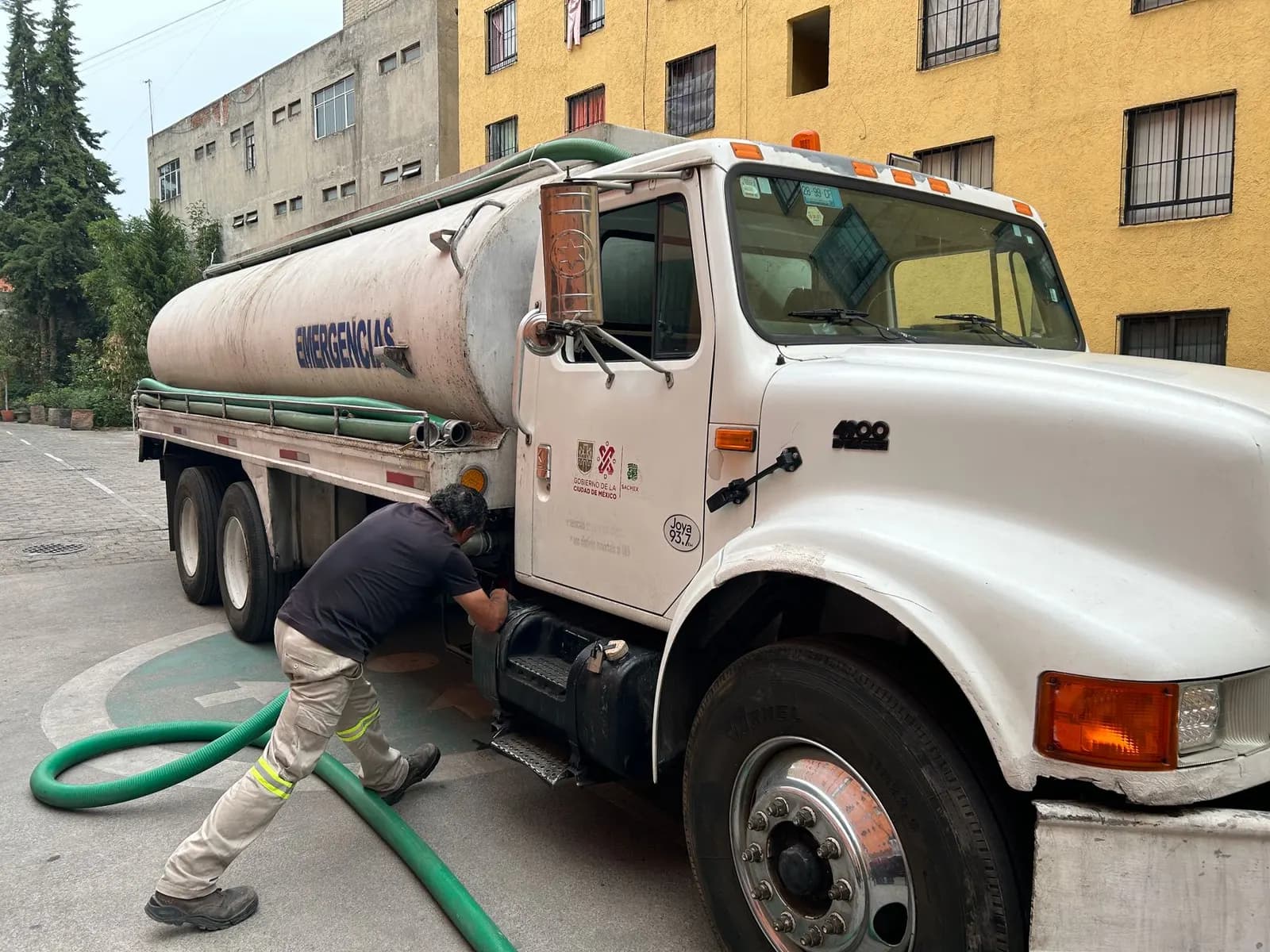 Tanker lorry with suction hose on a residential street